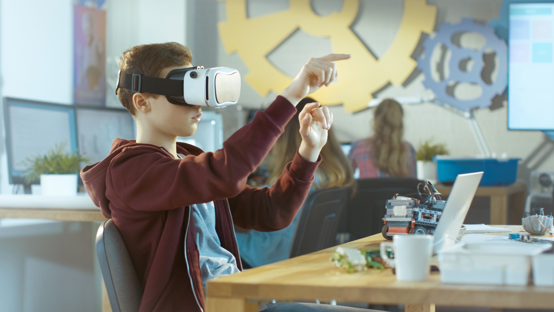 In a Computer Science Class Boy Wearing Virtual Reality Headset Works on a Programing Project.